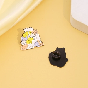 Cute enamel pin featuring colorful stacked cartoon cats playing together on a soft yellow base
