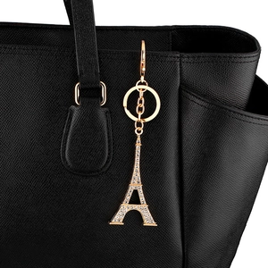 Porte-clés Tour Eiffel doré avec strass scintillants sur un sac à main en cuir noir
