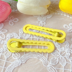 Close-up of yellow wavy hair clips on white lace with decorative flowers