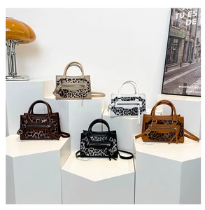 Detalle de cinco bolsos con estampado de leopardo en varios colores con borlas