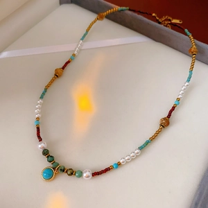 Detailed shot of bohemian turquoise and pearl necklace with colorful beads on velvet