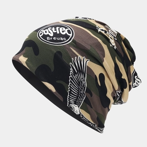Detail of camouflage knitted beanie featuring eagle wing print and logo on gray background