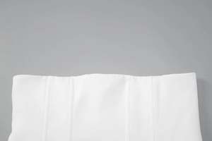 Detailed macro view of white slim-fit dress showing vertical stitching and corset structure