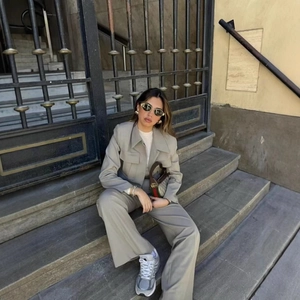 Completo chic grigio con blazer corto e pantaloni larghi in uno scatto di moda street