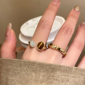 Detailed macro view of gold-plated tiger eye stone ring with shimmering micro-pave crystals