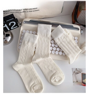 Dettagli delle trame a maglia di calze bianco crema su una macchina da scrivere vintage