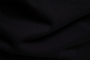 Gros plan du tissu en coton tricoté noir montrant une texture fine et des détails de tissage