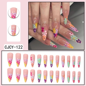 Long stiletto press-on nails featuring colorful floral patterns on a nude base
