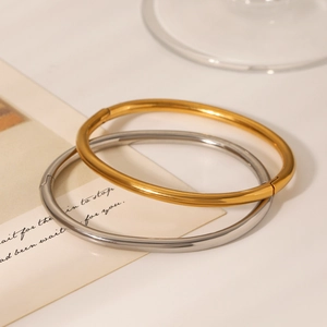 Close-up of polished gold and silver minimalist bangles on a decorative card