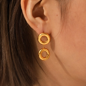 Gros plan de boucles d'oreilles à double maillon en acier plaqué or 18 carats sur un mannequin