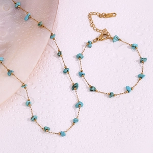 Detail view of gold-plated 18K necklace and bracelet set with blue turquoise stones