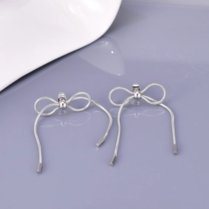 Detail shot of silver bow tassel earrings crafted with elegant snakichain metal fringe
