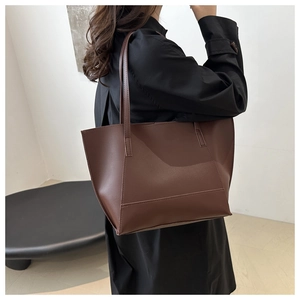 Rear view of a model carrying the large brown leather tote bag for everyday commuting