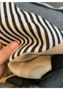 Close-up of black and white striped scarf fabric showing soft woven texture and drape