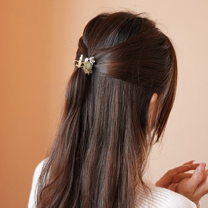 Detail of floral hair claw clip with pearl tassel on model's brown hair