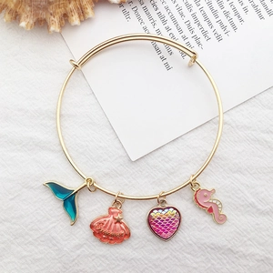 Detail of bohemian beach bracelet with colorful ocean enamel charms and golden summer motifs