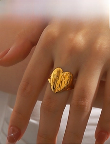 Detailed close-up of 18K gold heart ring with unique vertical handcrafted texture on model