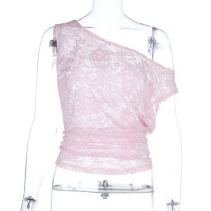 Detalle de top rosa asimétrico de encaje con bordado floral y textura transparente fina