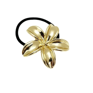 Minimalist elastic hair tie with a metallic golden flower charm on a black band