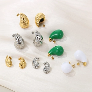 Close-up of 18K gold and silver plated teardrop earrings with hammered metal texture