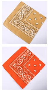 Detailed pattern of orange and yellow paisley polyester bandanas stacked vertically