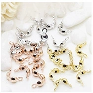 Macro view of gold, silver, and rose gold fold-over crimp ends on white stones