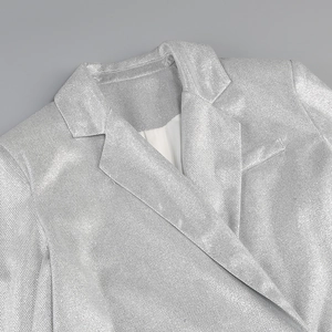 Detail shot of the silver sequin blazer lapel showing metallic fabric texture and shine