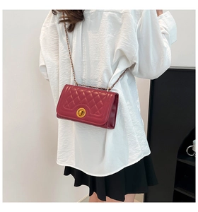 Quilted burgundy chain shoulder bag shown on model for elegant styling and scale