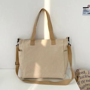 Detailed close-up of large canvas tote bag with side pockets and sturdy woven handles
