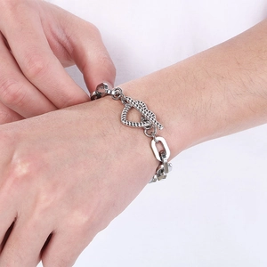 Dettaglio del bracciale a catena in titanio con chiusura a cuore indossato al polso