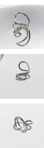 Three-view montage of a silver geometric irregular wrap ring with polished metallic finish