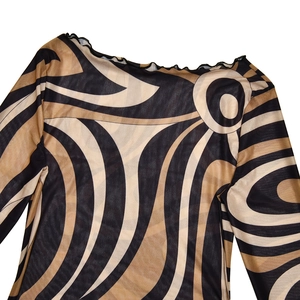 Close-up of wavy mesh fabric on a long sleeve dress with sheer black and beige patterns