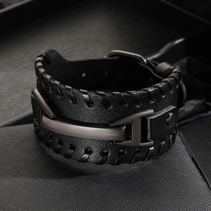 Close-up of a black wide leather bracelet with braided texture and metal buckle detail