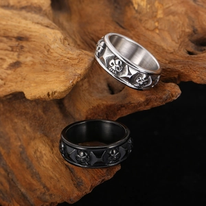 Close-up of vintage skull rings in silver and black finish on a rustic wood stand