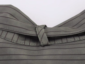 Macro detail of dark green fabric with black pinstripes and fine textile texture