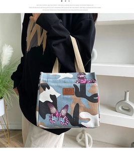 Détail de l'imprimé papillon bleu et logo en cuir sur le sac à déjeuner en oxford épais