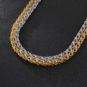 Macro detail of gold and silver Byzantine weave stainless steel chains for men
