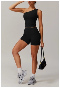 Détail du haut de sport noir à une épaule et du short à taille haute en tissu respirant