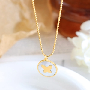 Golden bead chain necklace with a round white shell butterfly pendant in minimalist style