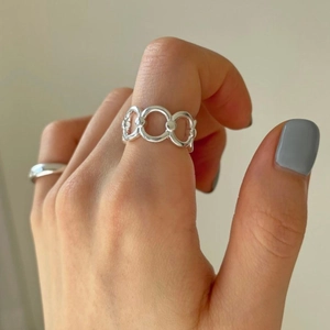 Detailed view of sterling silver chain ring worn on finger with modern hollow design