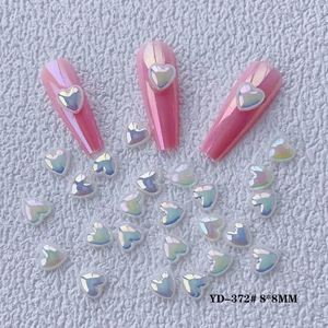 Detail of aurora heart nail charms size 8x8mm on long pink nails with pearl finish