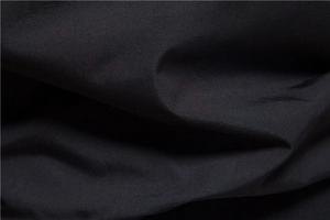 Detailed close-up of smooth black fabric texture and premium weaving on the jacket