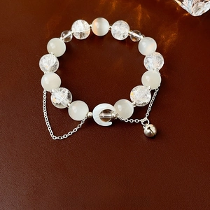 Detailed macro view of moon charm bracelet with cracked glass and cat's eye beads