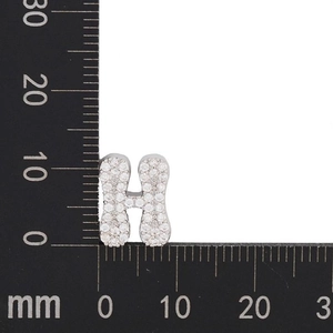 Macro view of crystal-encrusted letter H charm showing measurements on a metric scale