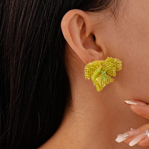 Orecchini a fiore con perline di vetro verdi indossati da una modella, stile minimalista