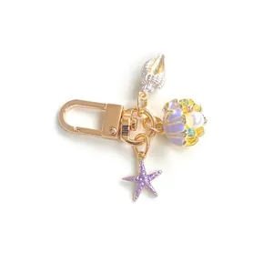 Ocean theme keychain with purple starfish, shell and pearl charms on gold ring