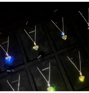 Macro shot of heart shaped yellow gemstone pendants on silver chains in jewelry box