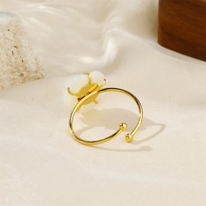 Macro shot of 18k gold plated ring with a white shell flower and pearl detail