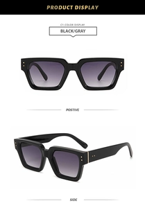 Close-up of vintage square black sunglasses with metal rivets and grey gradient lenses