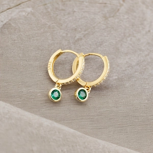 Detail of S925 silver gold hoop earrings with green gemstone and pavé zircon settings